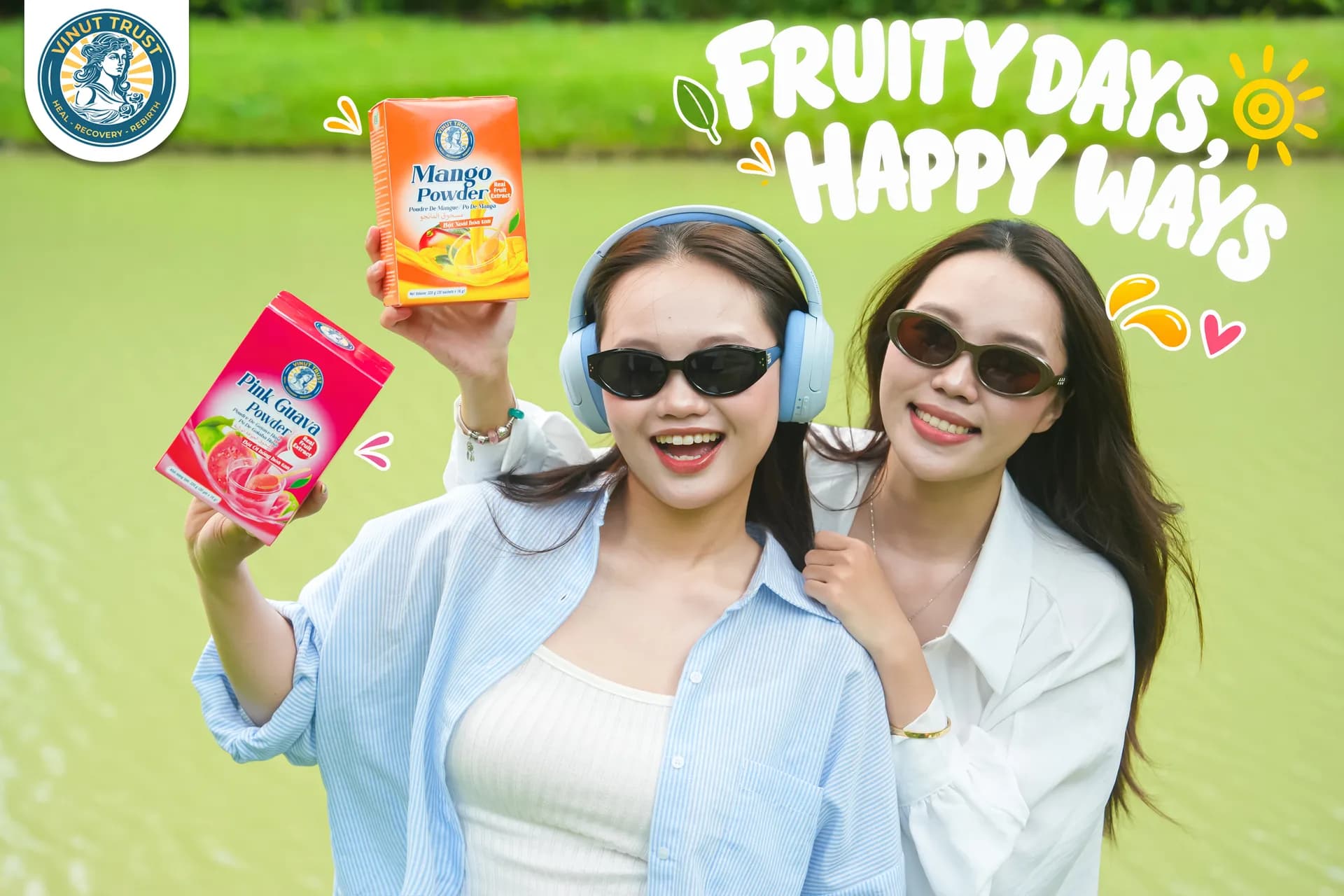 Two people outdoors holding VINUT TRUST mango and pink guava fruit powder packs